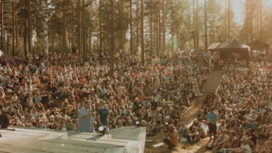Hundreds of scouts attending an outdoor singalong event.